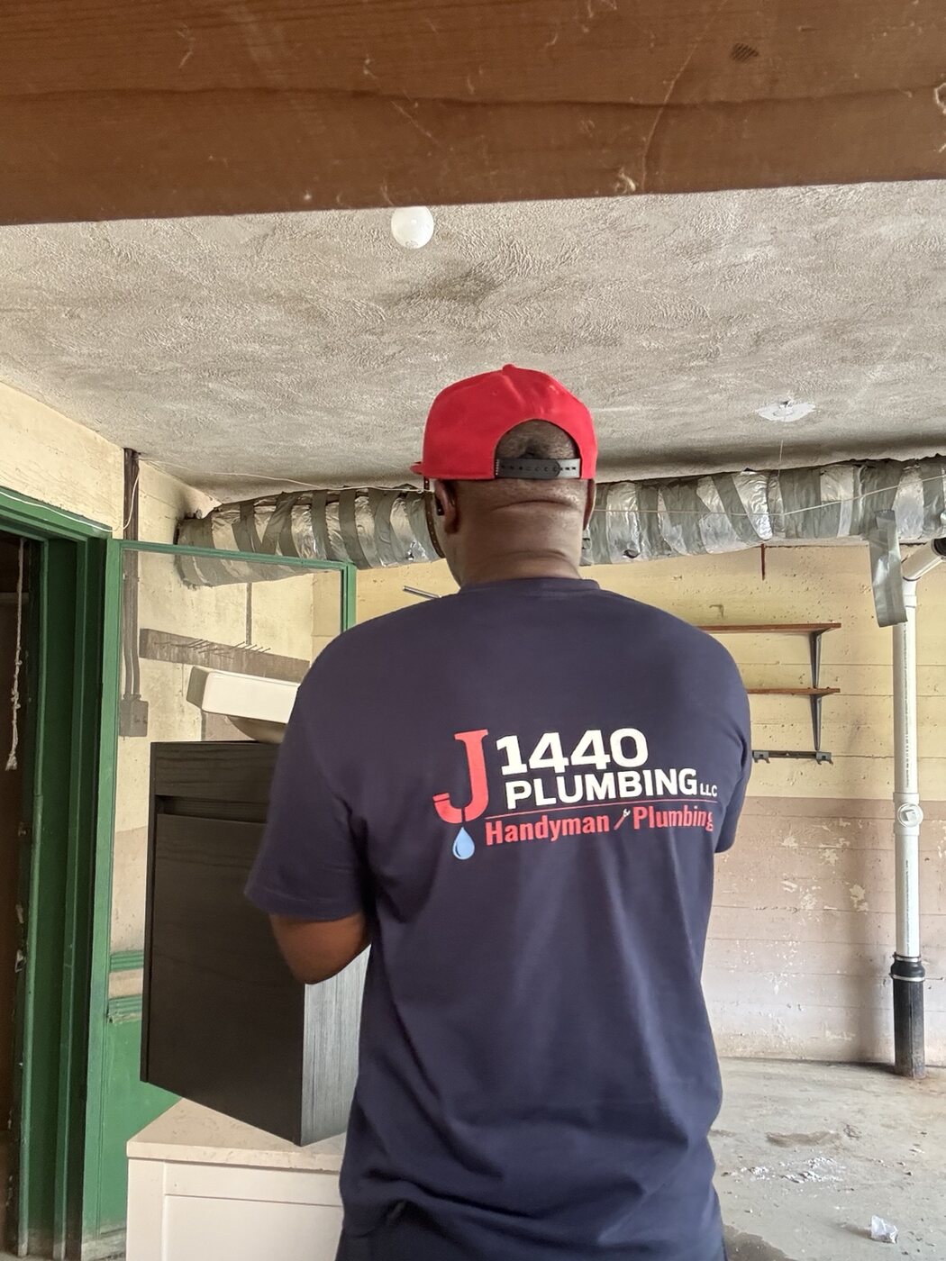 J 1440 Plumbing team member working on site in branded clothing