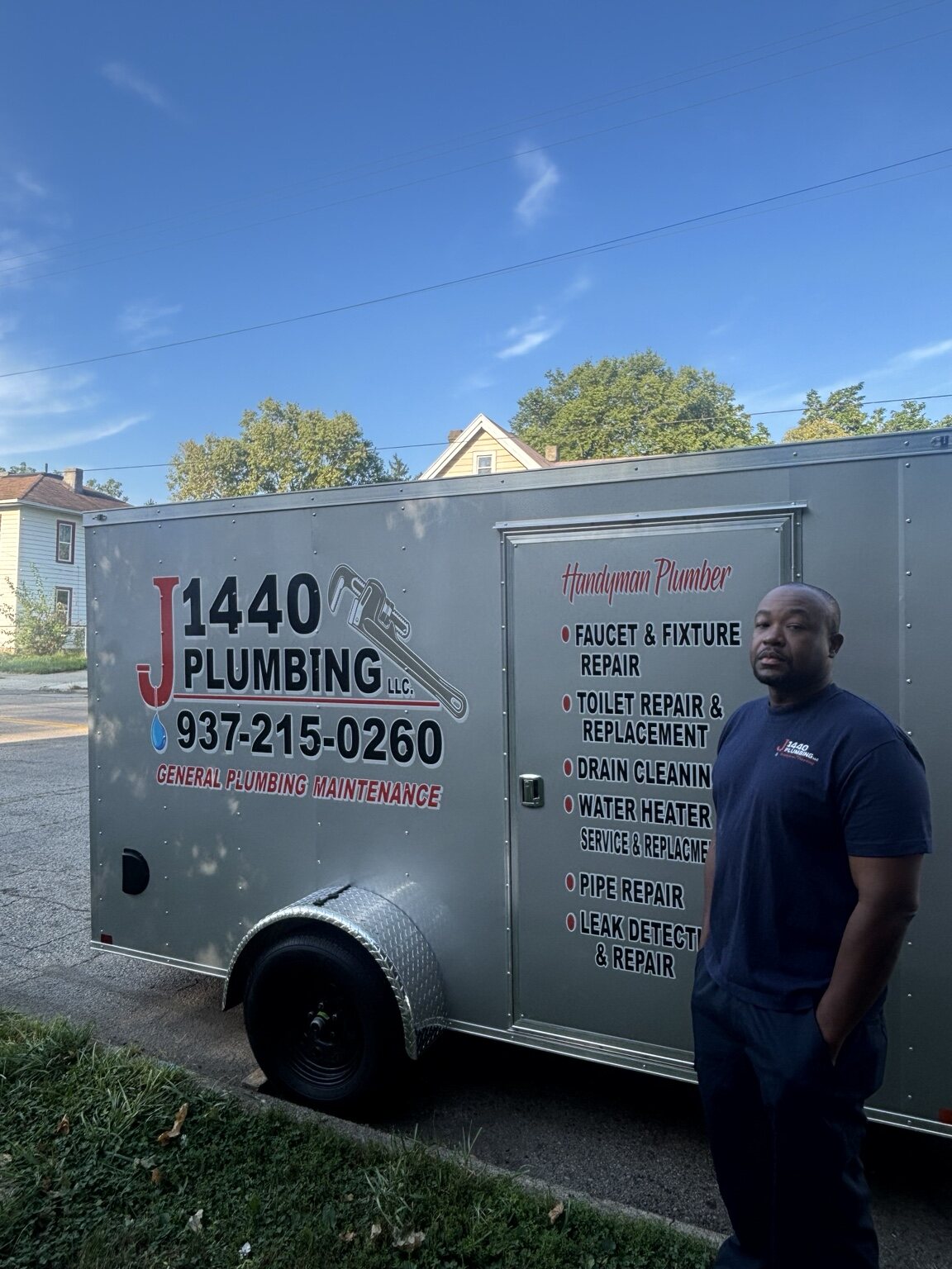 J 1440 Plumbing owner standing beside the branded service trailer